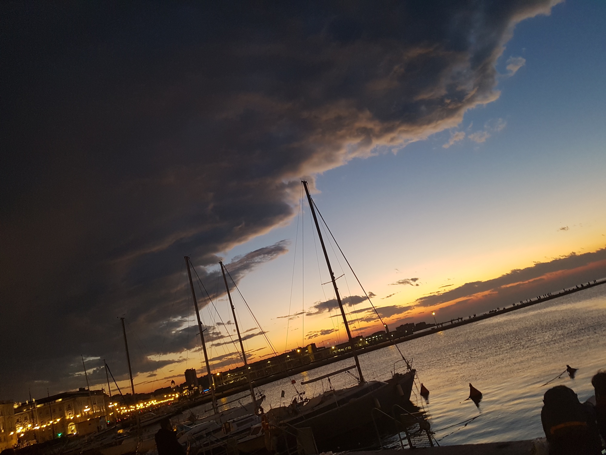 Sailboats beneath a dramatic sunset at an Adriatic harbour