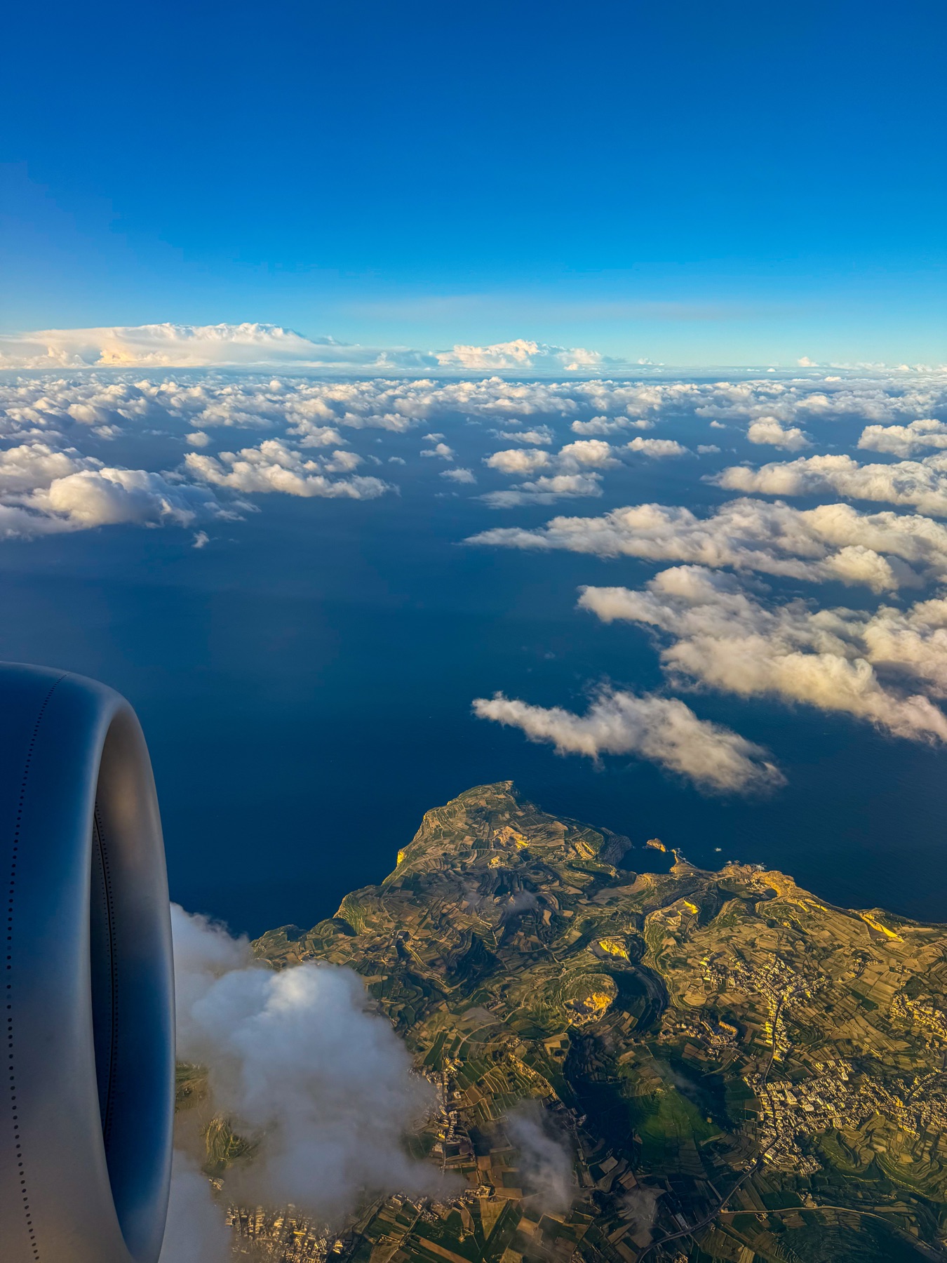 Malta seen through a plane window above the clouds