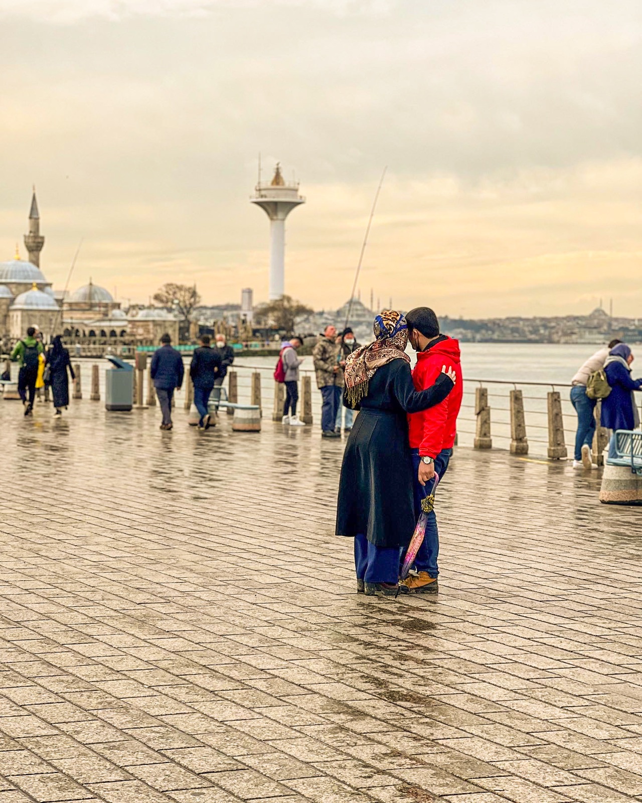 A couple standing together on a rainy Istanbul waterfront